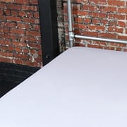 White Fluid-proof Flat Sheet on a galvanised bed frame against a brick wall