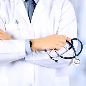 Torso of doctor in a white coat holding a stethoscope for a blog on Medical Fetishism