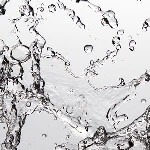 Image to illustrate Vulva Ejaculation Clear liquid splash over a pale grey background
